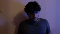 a man standing in front of a blue wall